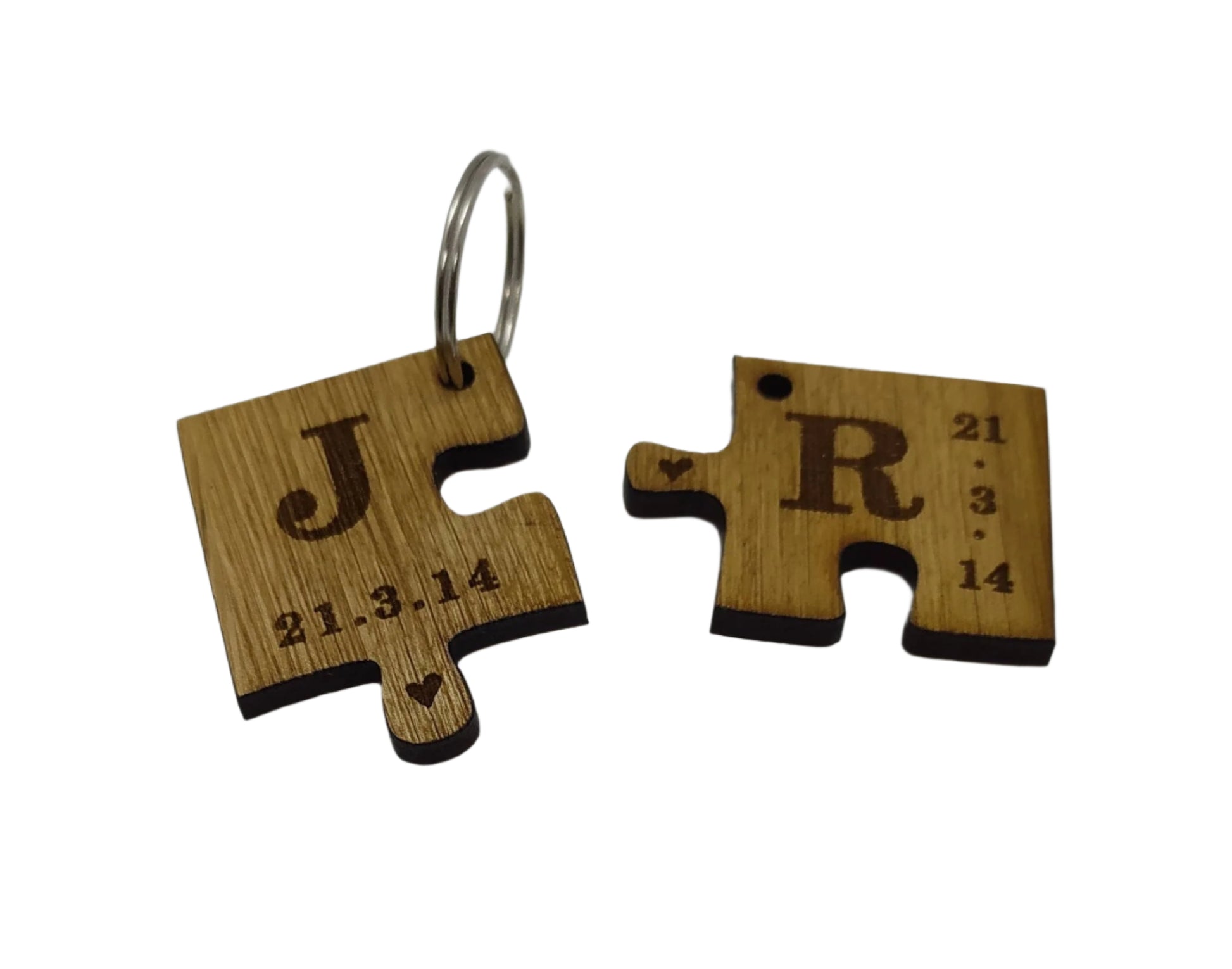 2 puzzle piece keyrings engraved with initials and a special date.