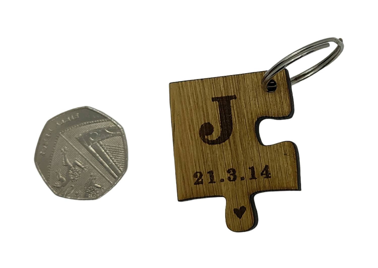 2 puzzle piece keyrings engraved with initials and a special date.