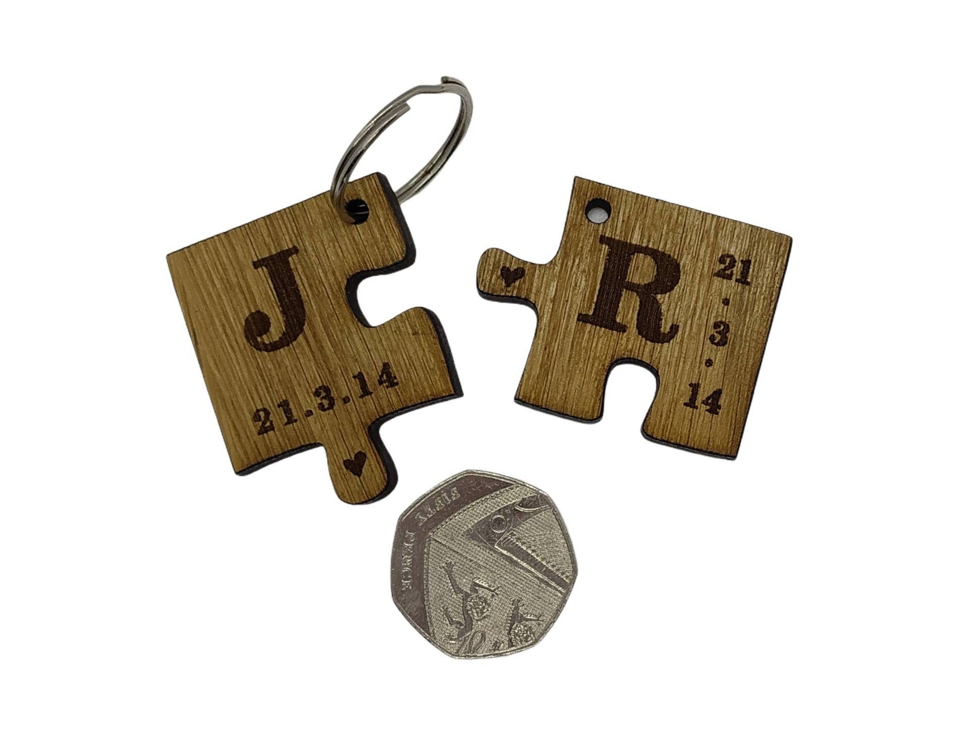 2 puzzle piece keyrings engraved with initials and a special date.