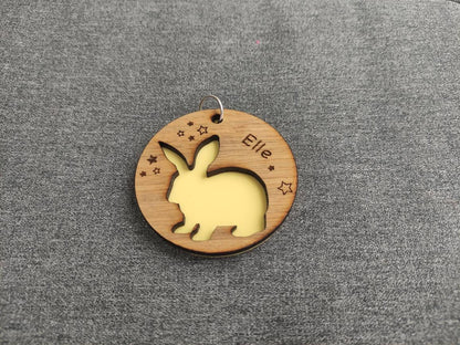 Circular keyring with a cut-out bunny rabbit design backed with colourful acrylic, laser engraved with a personalised name on oak veneer.