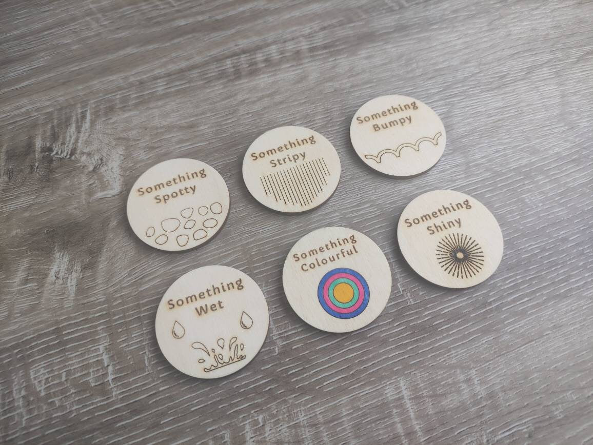 Wooden discs with engraved scavenger hunt prompts, featuring different things to find.