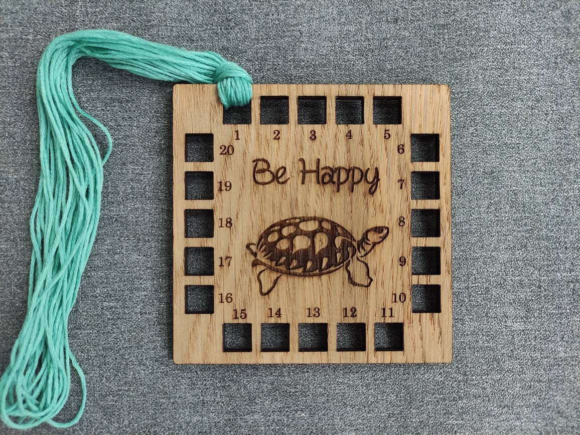 Square shape thread holder, with tortoise and "be happy" engraved in the middle. 20 holes for thread. 