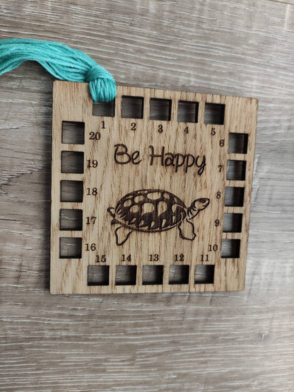 Square shape thread holder, with tortoise and "be happy" engraved in the middle. 20 holes for thread. 