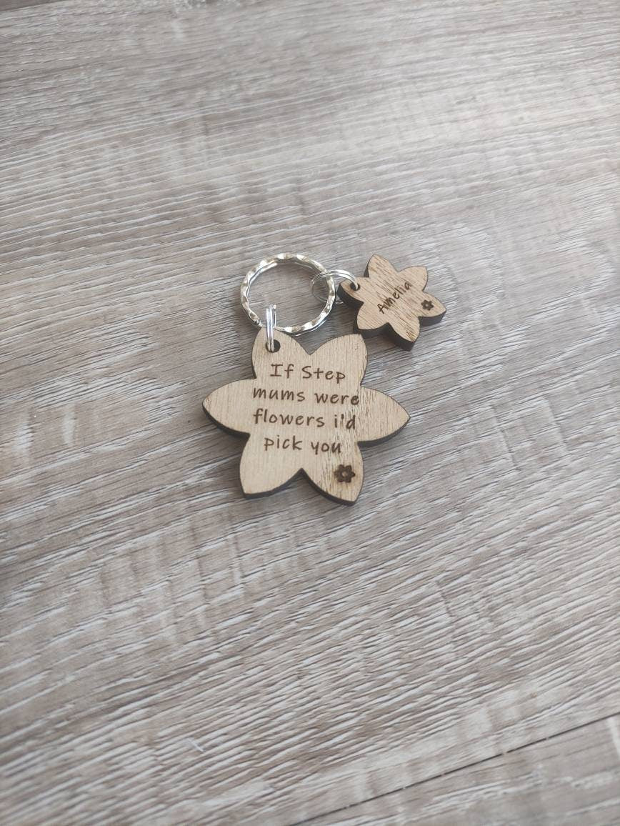 Flower-shaped keyring with "If Step mums were flowers I'd pick you" engraved, featuring smaller charms with a child's name.