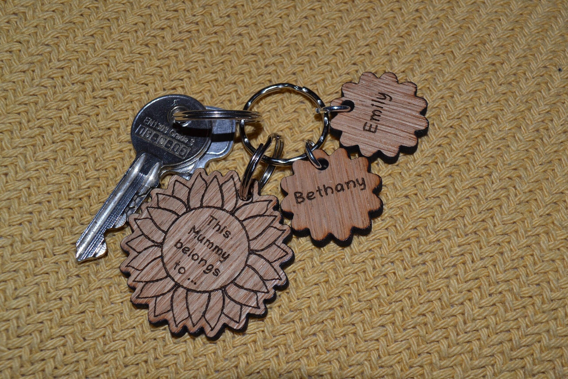 Sunflower-style keyring engraved with "This (any name) belongs to..." and customisable with additional charms.