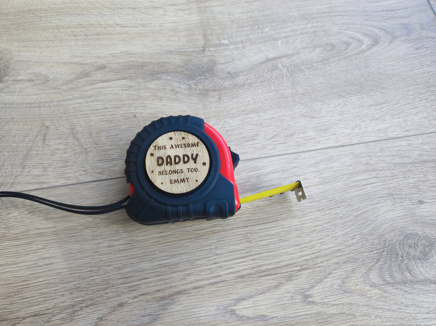 Personalised tape measure with a wooden disc engraved with This Awesome DADDY belongs too...