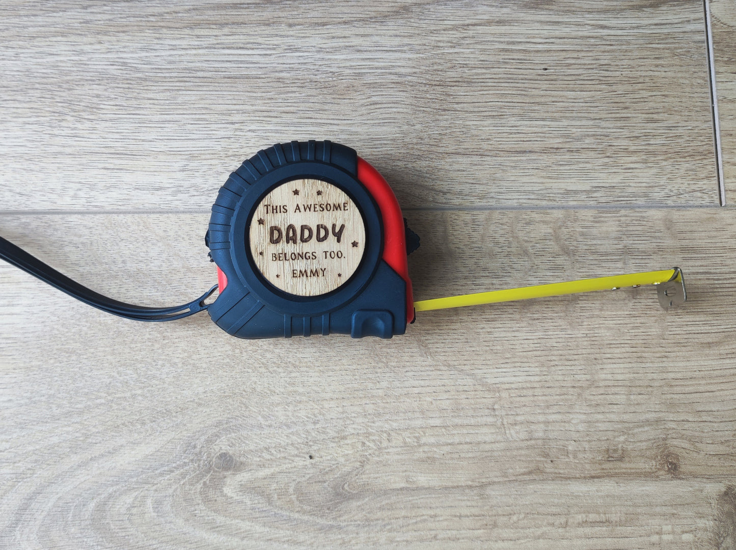 Personalised tape measure with a wooden disc engraved with This Awesome DADDY belongs too...