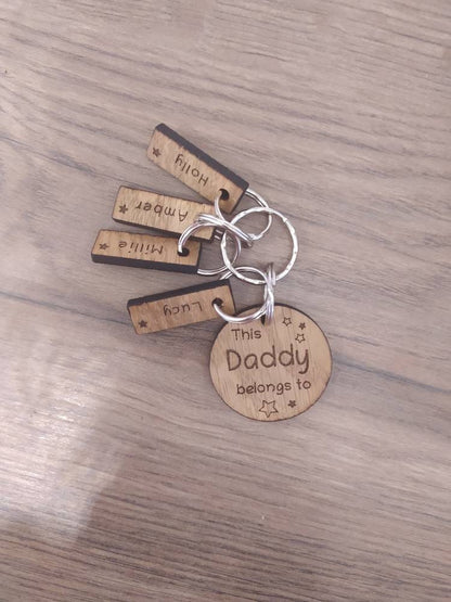 This Daddy Belongs To keychain with added charms, engraved with names and a star.
