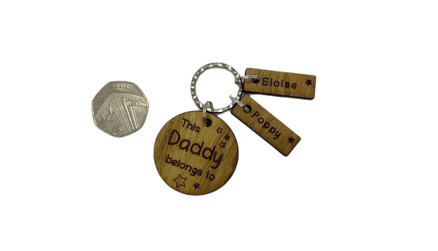 This Daddy Belongs To keychain with added charms, engraved with names and a star.