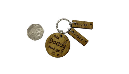 This Daddy Belongs To keychain with added charms, engraved with names and a star.