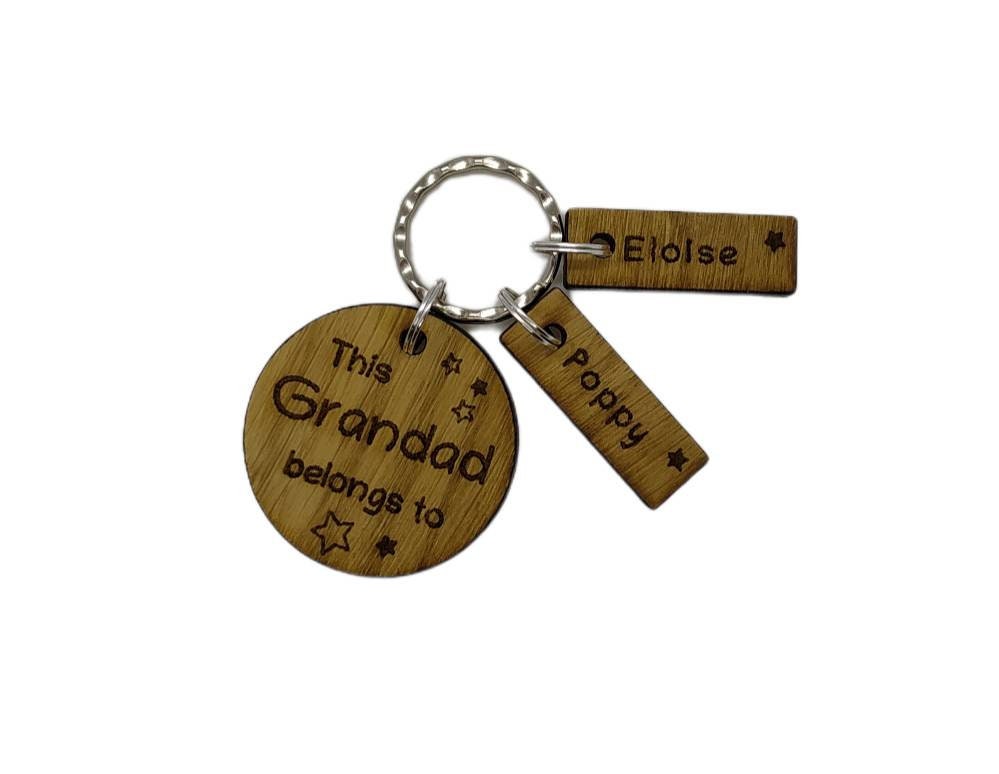 This Daddy Belongs To keychain with added charms, engraved with names and a star.