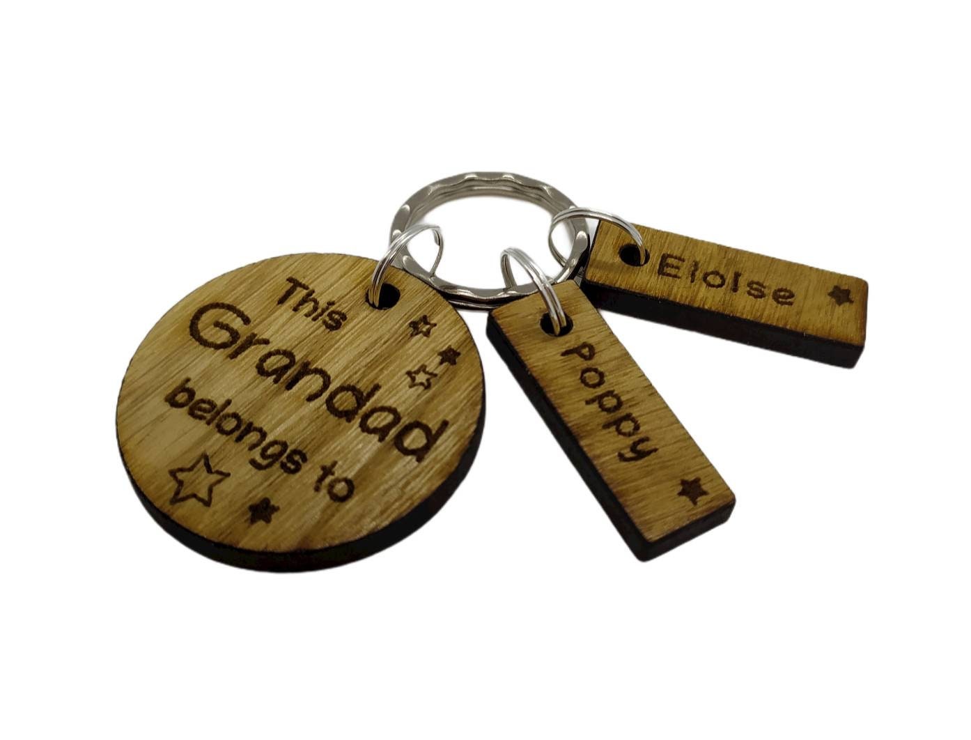 This Daddy Belongs To keychain with added charms, engraved with names and a star.