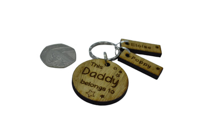 This Daddy Belongs To keychain with added charms, engraved with names and a star.