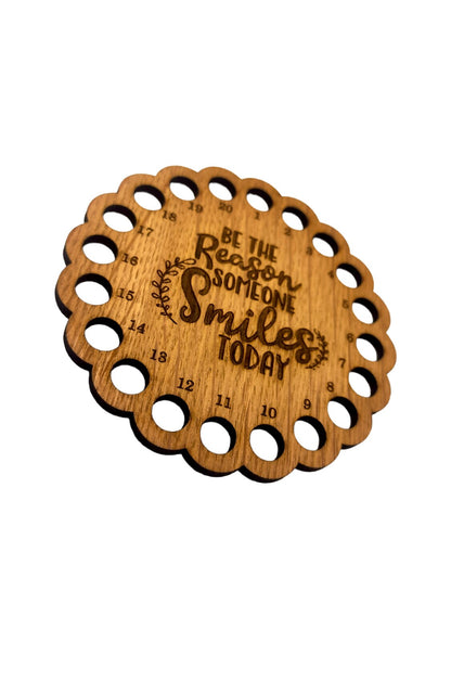 Thread holder with the words 'Be the reason someone smiles today' engraved in the middle, featuring 20 holes for organising embroidery threads.