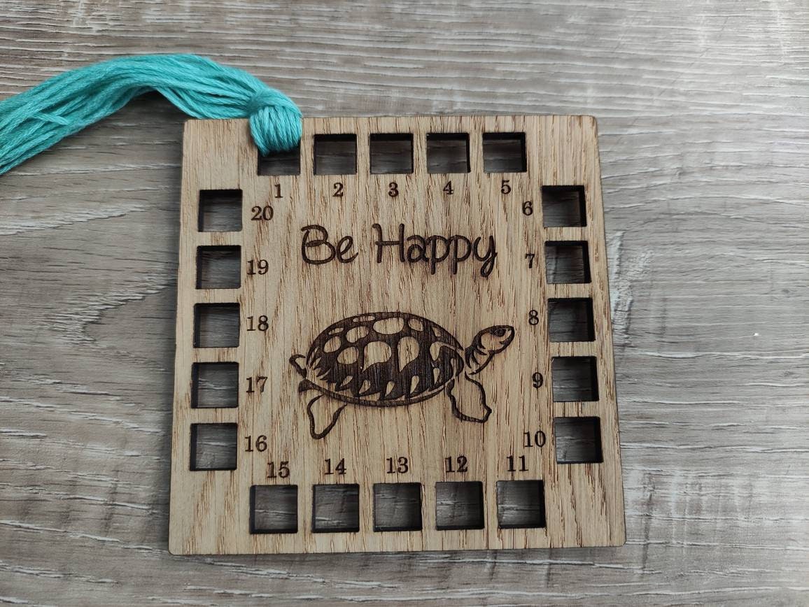 Square shape thread holder, with tortoise and "be happy" engraved in the middle. 20 holes for thread. 