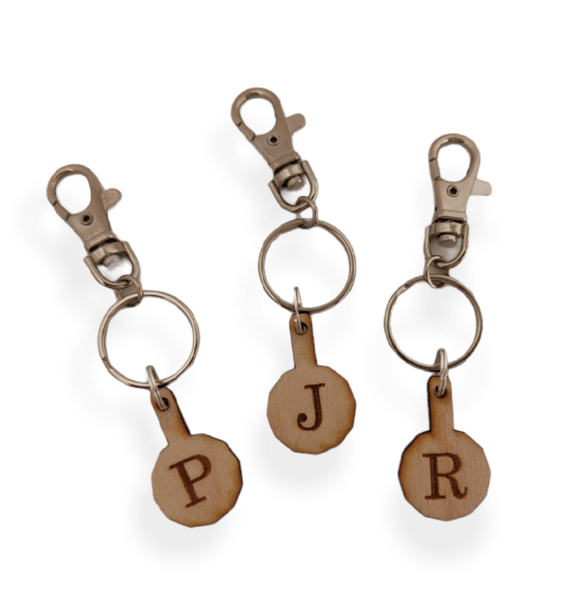 Personalised trolley keyring with a letter initial or Christmas design, same shape and thickness as a £1 coin, attached to a split ring and clip.