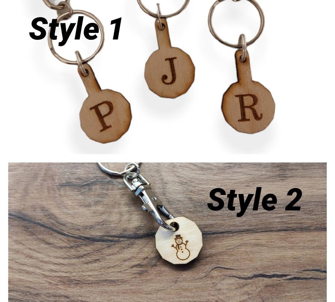 Personalised trolley keyring with a letter initial or Christmas design, same shape and thickness as a £1 coin, attached to a split ring and clip.