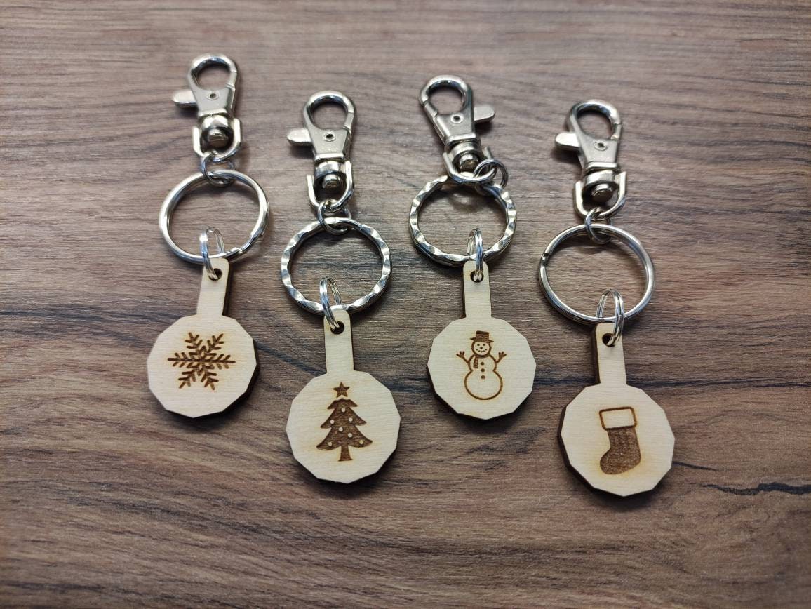 Personalised trolley keyring with a letter initial or Christmas design, same shape and thickness as a £1 coin, attached to a split ring and clip.