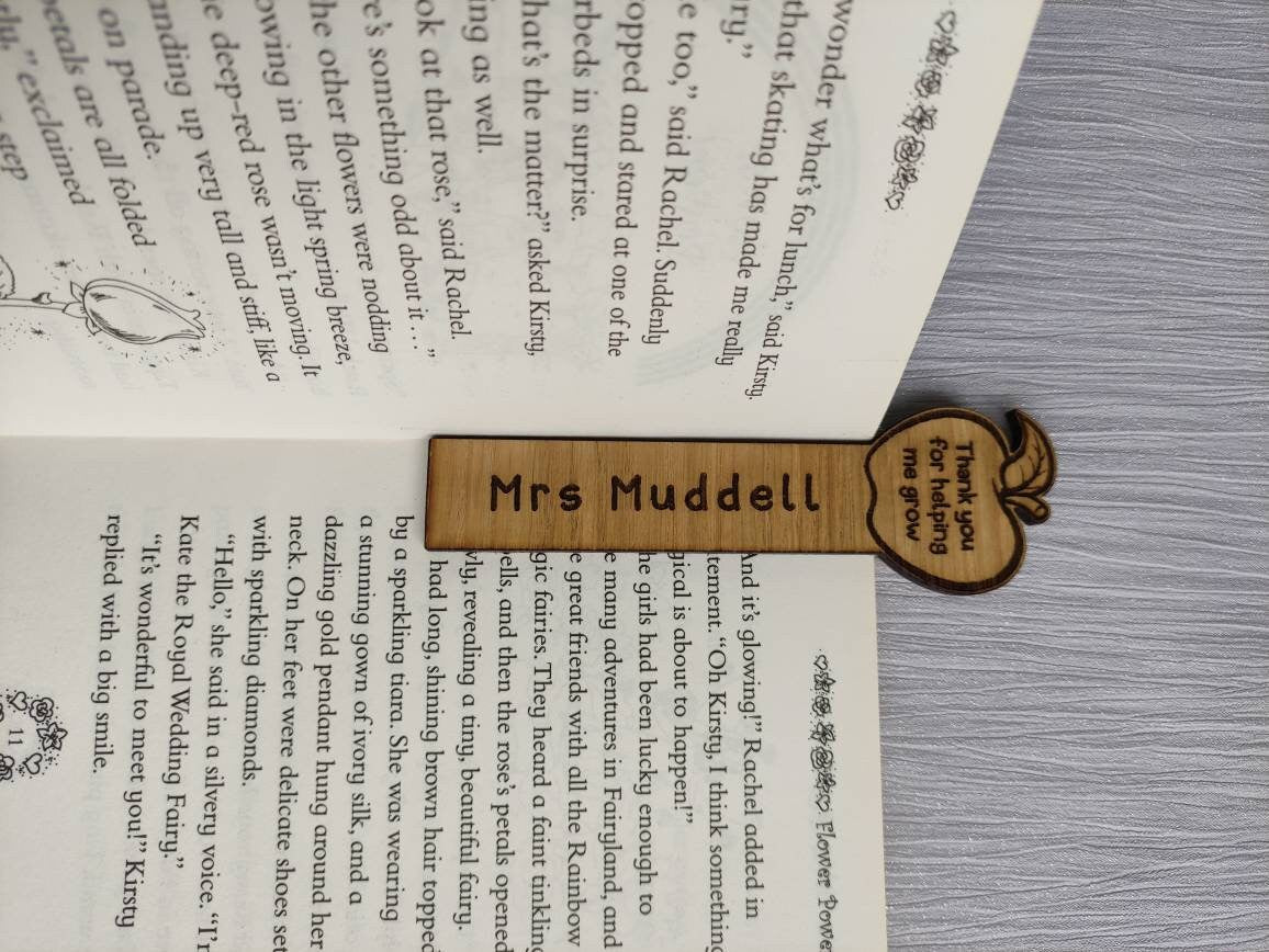 Wooden bookmark with custom name engraving, featuring a flower or apple design at the top.