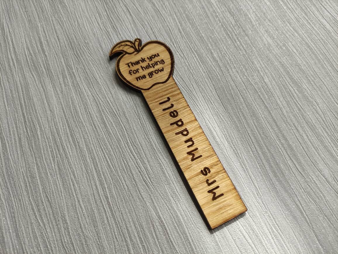 Wooden bookmark with custom name engraving, featuring an apple design at the top.