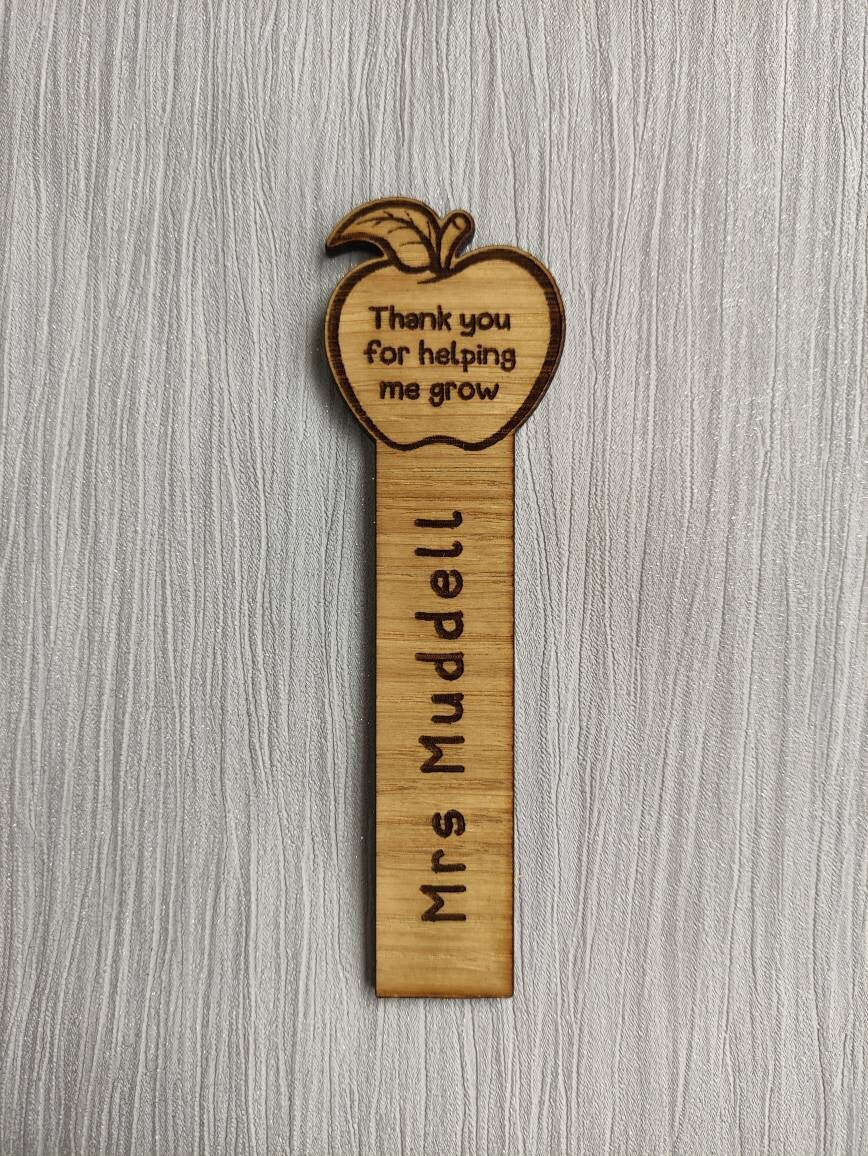 Wooden bookmark with custom name engraving, featuring an apple design at the top.