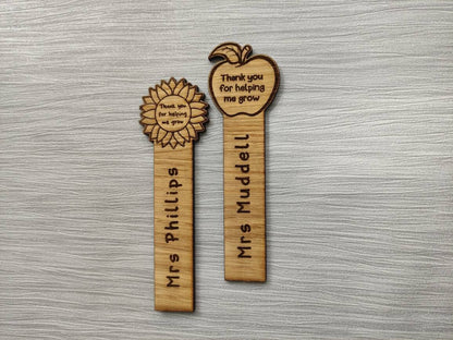 Wooden bookmark with custom name engraving, featuring a flower or apple design at the top.