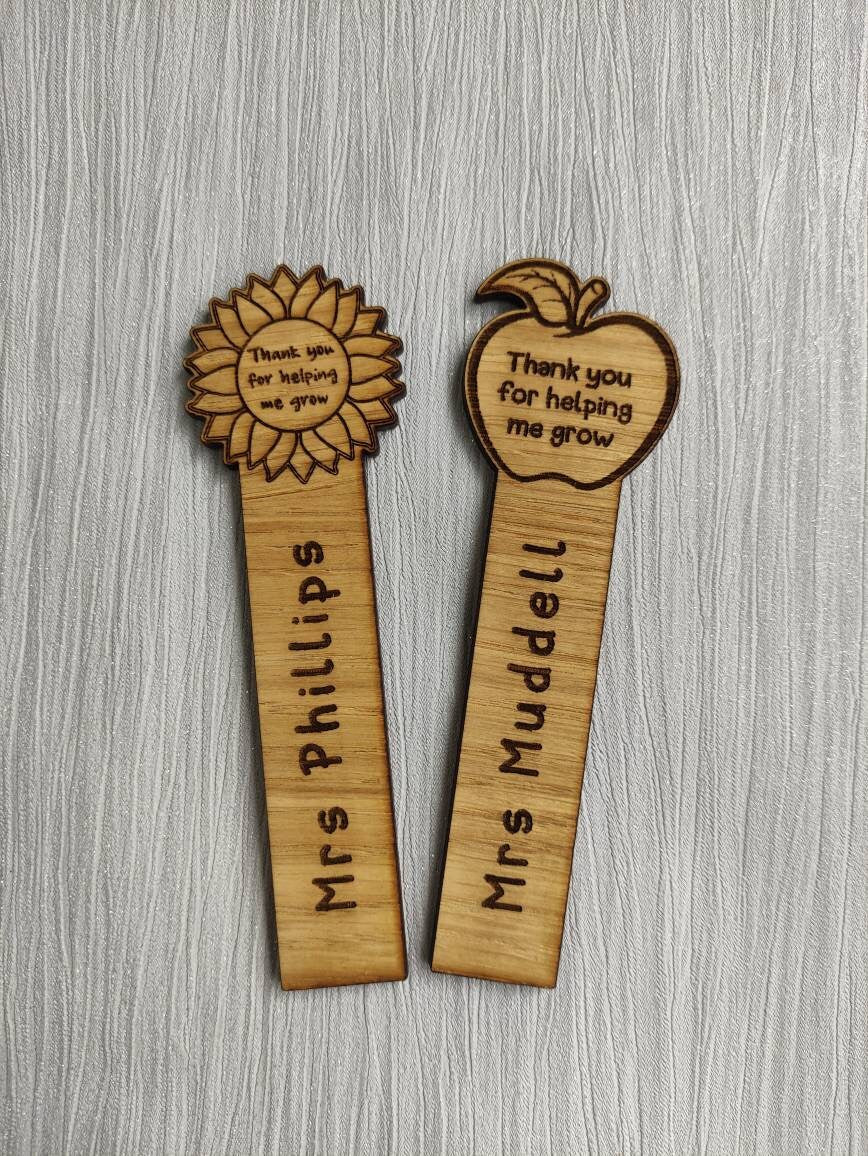 Wooden bookmark with custom name engraving, featuring a flower or apple design at the top.