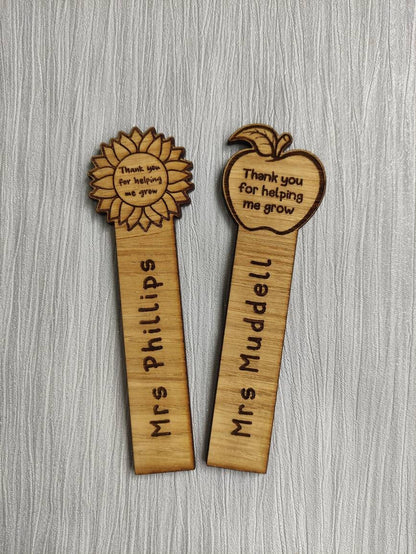 Wooden bookmark with custom name engraving, featuring a flower or apple design at the top.