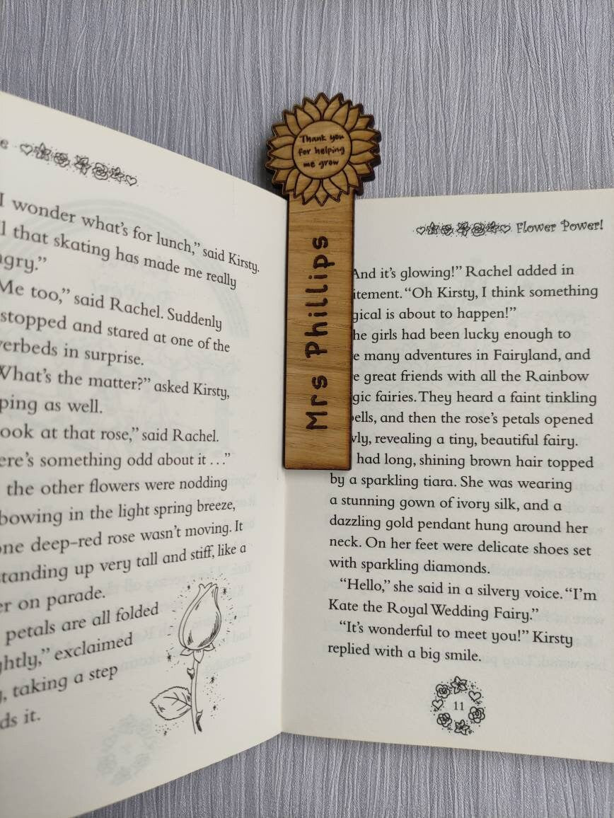Wooden bookmark with custom name engraving, featuring a flower design at the top.