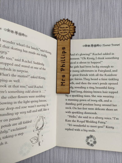 Wooden bookmark with custom name engraving, featuring a flower design at the top.