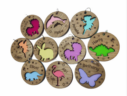 Round wooden keyring with a cut-out triceratops design, personalised with an engraved name, backed with colourful acrylic.