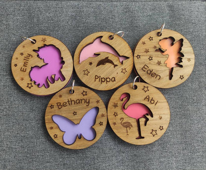 Circular wooden keyring with a unicorn cut-out, backed with colourful acrylic and personalised with an engraved name.