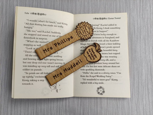Wooden bookmark with custom name engraving, featuring a flower or apple design at the top.