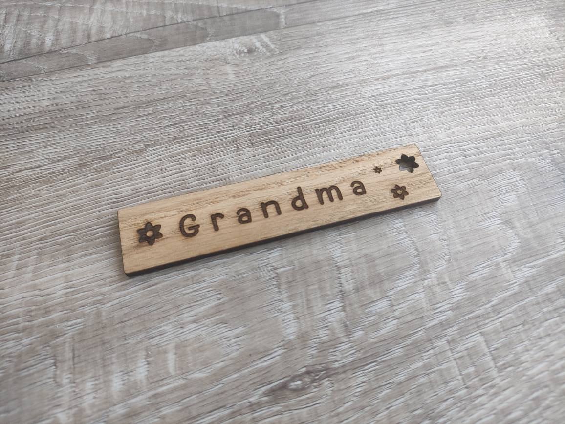 Personalised wooden bookmark engraved with flower designs, featuring two coloured ribbons tied at the top. A thoughtful and custom gift for book lovers, made from high-quality wood.