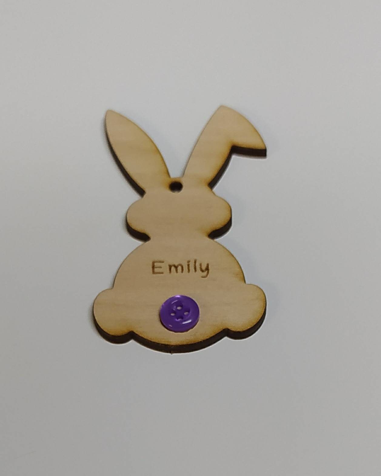 Easter bunny-shaped hanging decoration, engraved with a personalised name and featuring a coloured button as the tail.