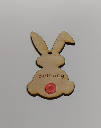 Easter bunny-shaped hanging decoration, engraved with a personalised name and featuring a coloured button as the tail.