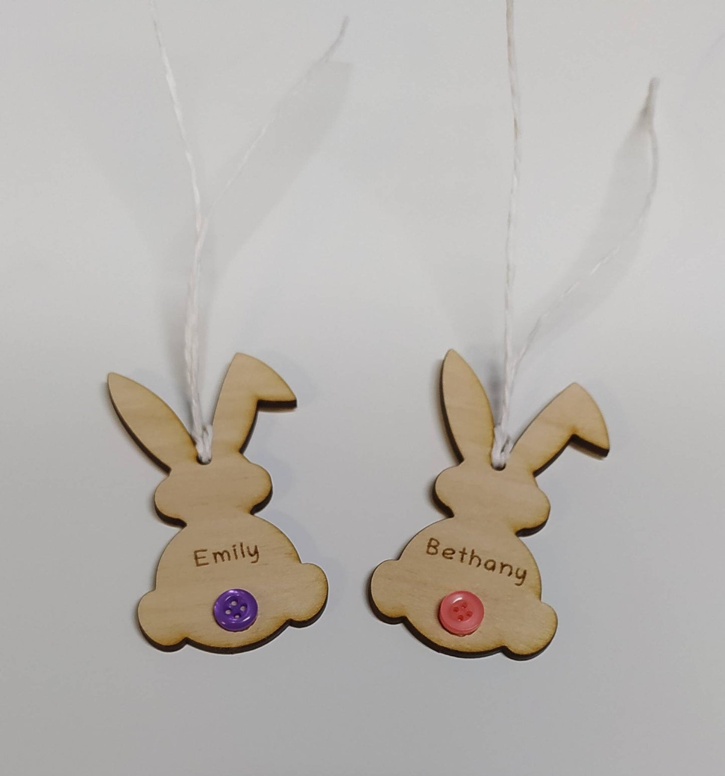 Easter bunny-shaped hanging decoration, engraved with a personalised name and featuring a coloured button as the tail.