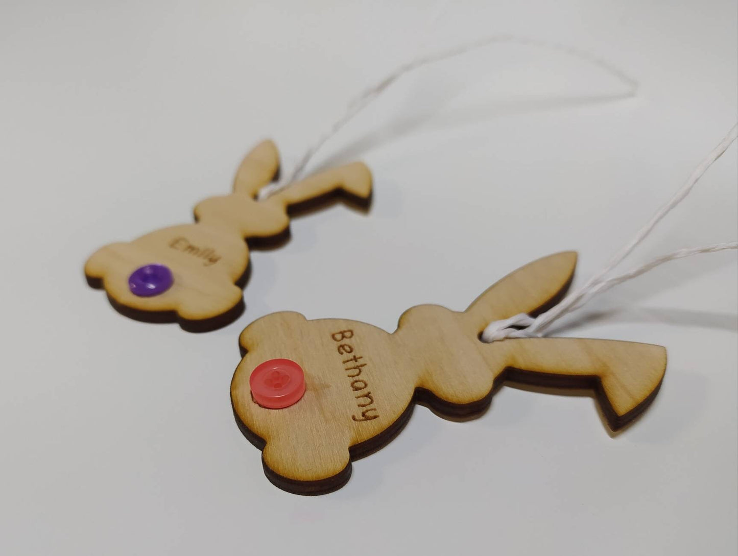 Easter bunny-shaped hanging decoration, engraved with a personalised name and featuring a coloured button as the tail.