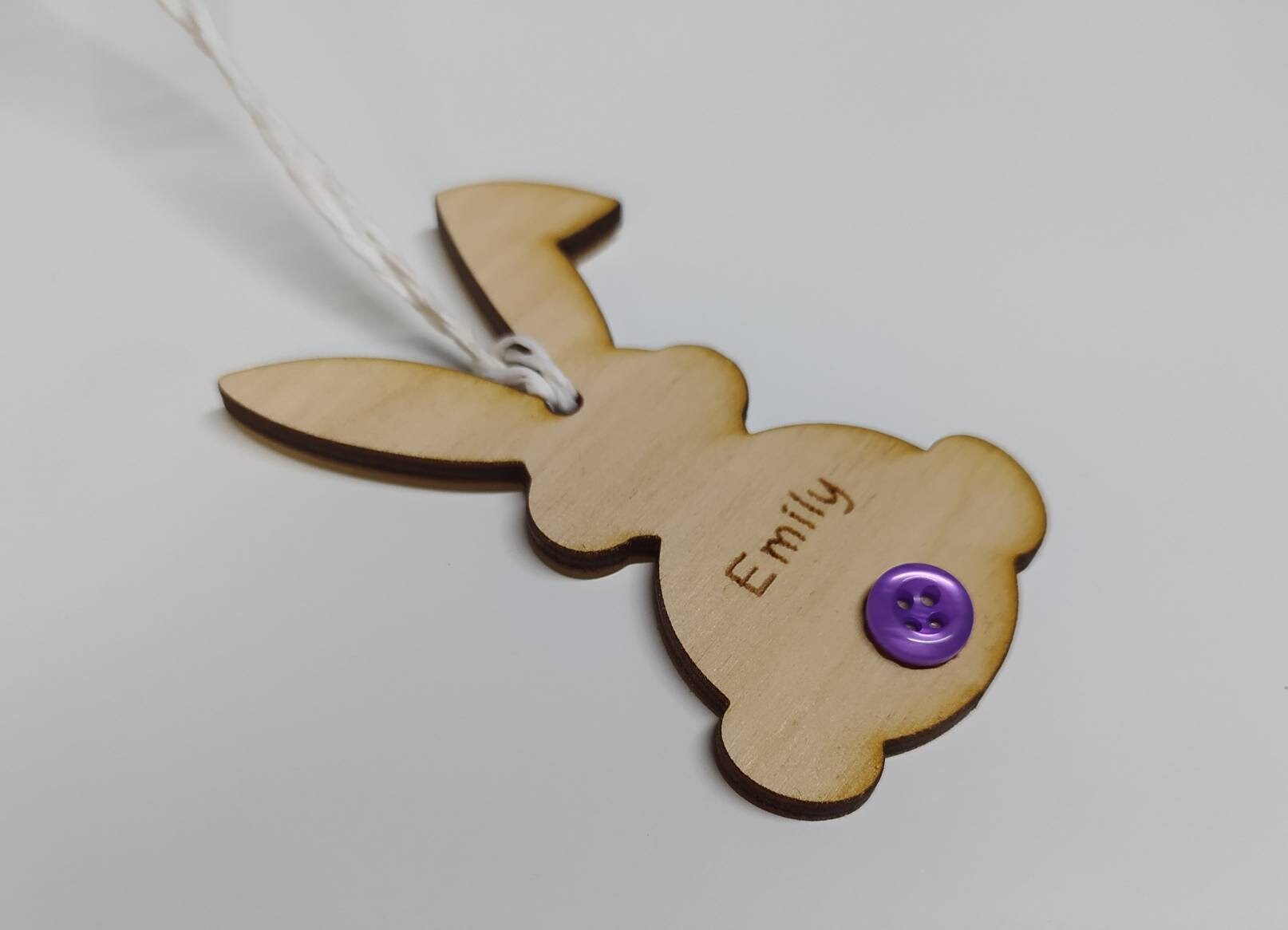 Easter bunny-shaped hanging decoration, engraved with a personalised name and featuring a coloured button as the tail.