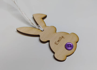 Easter bunny-shaped hanging decoration, engraved with a personalised name and featuring a coloured button as the tail.