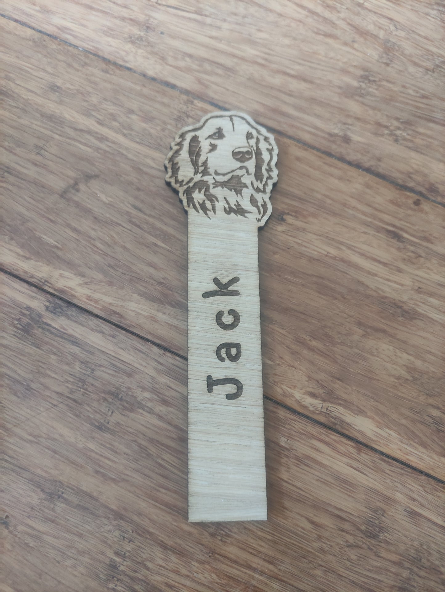 Personalised oak veneer dog bookmark with a dog design at the top and a custom name engraved vertically down the middle. Perfect for children's gifts, stocking stuffers, and party bag fillers.